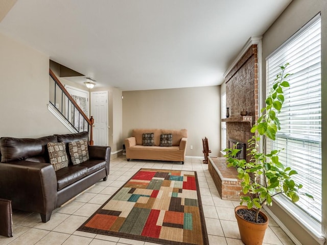 tiled living room featuring a healthy amount of sunlight and a brick fireplace