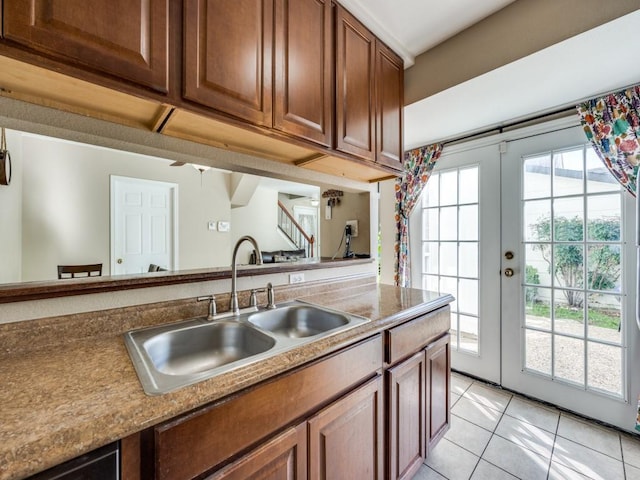 kitchen featuring french doors, light tile patterned flooring, and sink