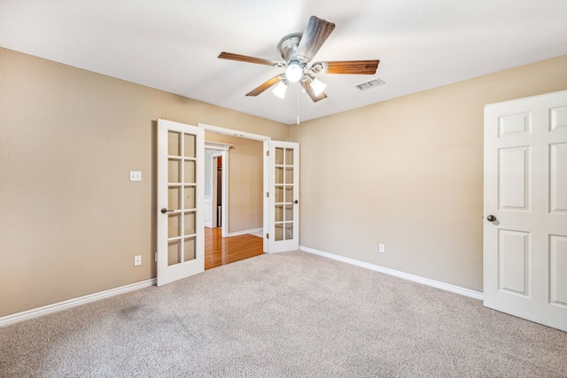 spare room featuring carpet flooring, ceiling fan, and french doors