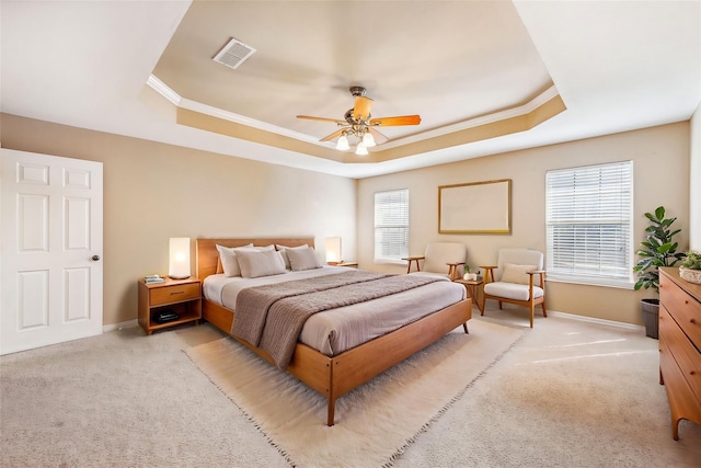 bedroom with a raised ceiling, crown molding, light carpet, and ceiling fan