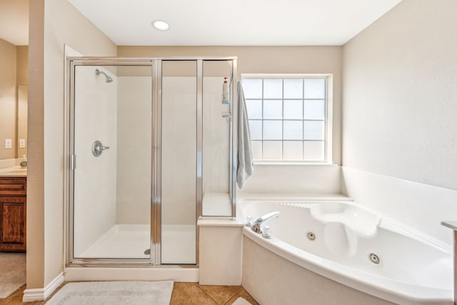 bathroom featuring shower with separate bathtub, vanity, and tile patterned floors