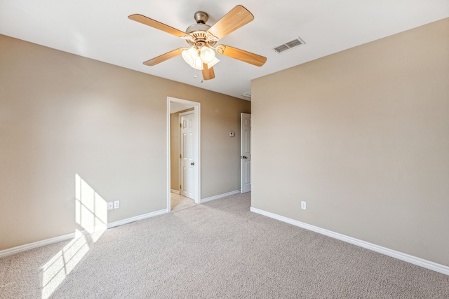 carpeted spare room featuring ceiling fan