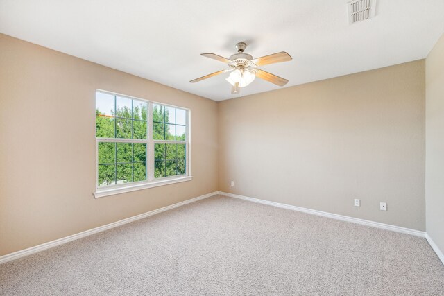 carpeted spare room with ceiling fan