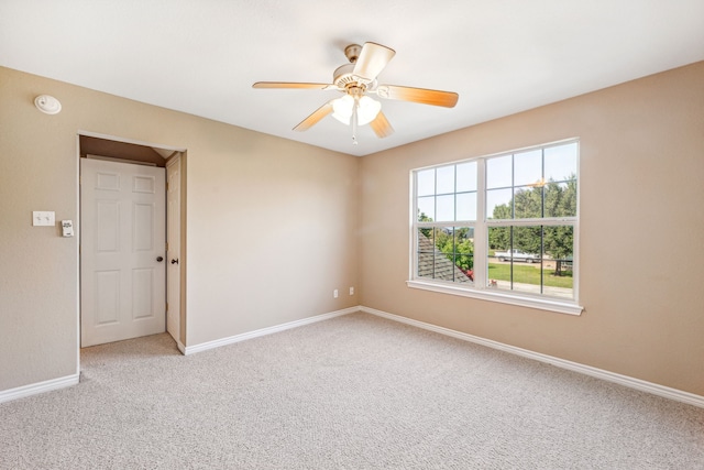 carpeted spare room with ceiling fan