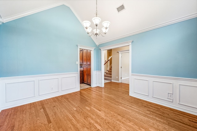 unfurnished room featuring a notable chandelier, crown molding, vaulted ceiling, and light hardwood / wood-style floors