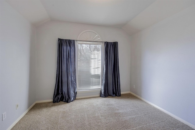 carpeted empty room with lofted ceiling