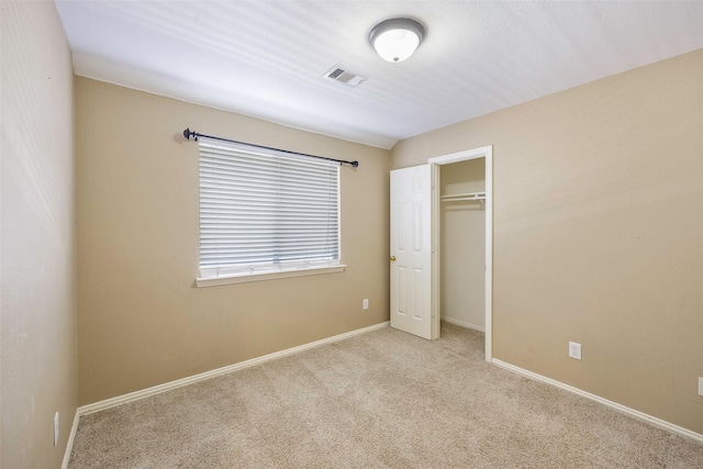 unfurnished bedroom featuring a closet and light carpet