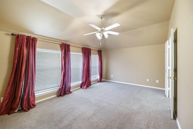 spare room with ceiling fan, light colored carpet, and vaulted ceiling