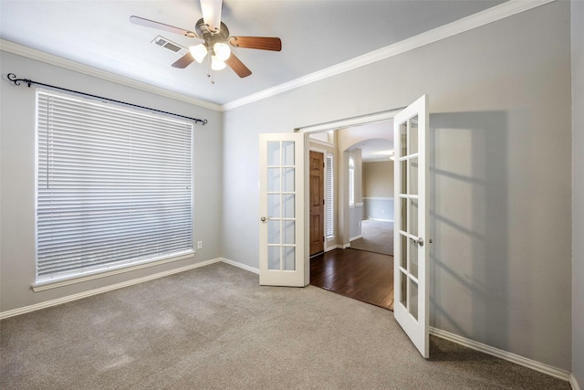 empty room featuring french doors, ceiling fan, ornamental molding, and carpet floors