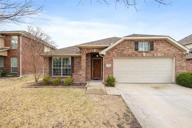 view of front facade with a front lawn, brick siding, driveway, and an attached garage