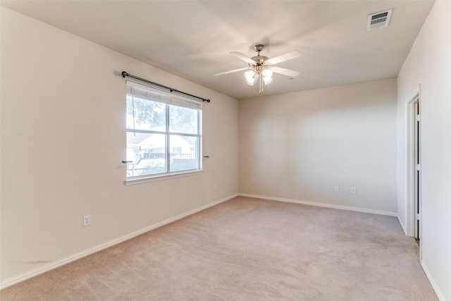 spare room featuring ceiling fan and light carpet