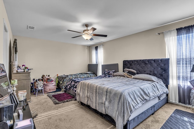 bedroom featuring ceiling fan, light colored carpet, and multiple windows