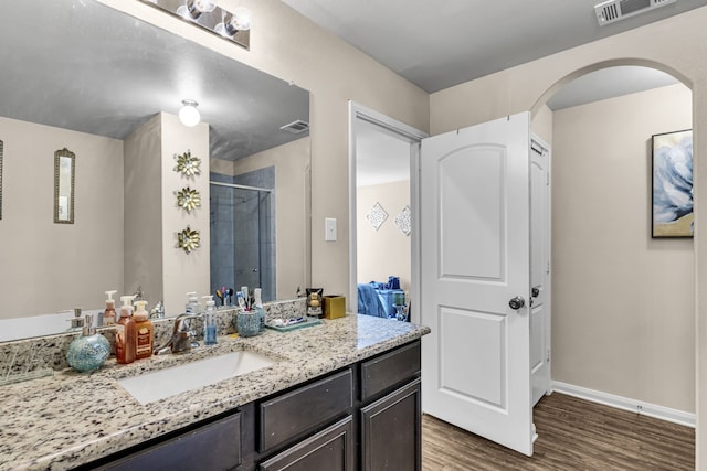 bathroom featuring hardwood / wood-style flooring, vanity, and a shower with shower door