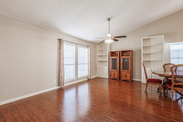 living room with ceiling fan, dark hardwood / wood-style flooring, vaulted ceiling, and a textured ceiling