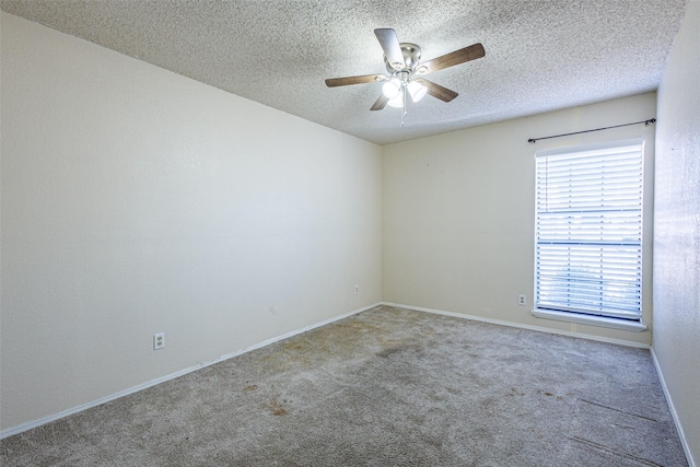 carpeted spare room featuring ceiling fan and a textured ceiling