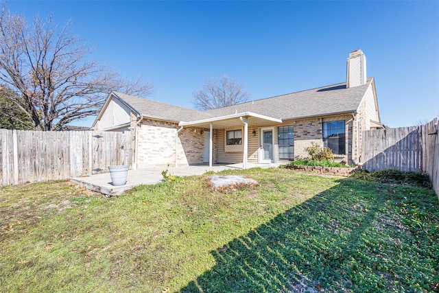 ranch-style home with a front yard and a patio area