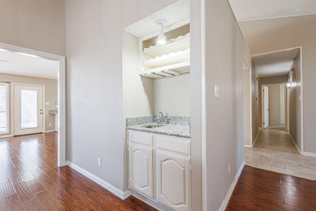 hallway featuring sink and dark wood-type flooring