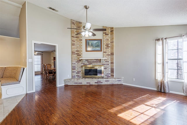 unfurnished living room featuring wood-type flooring, a fireplace, vaulted ceiling, and a textured ceiling