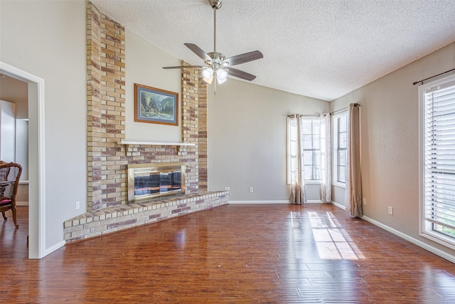 unfurnished living room featuring lofted ceiling, hardwood / wood-style floors, and a brick fireplace