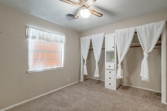 unfurnished bedroom with ceiling fan and light colored carpet