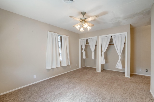 carpeted spare room featuring ceiling fan