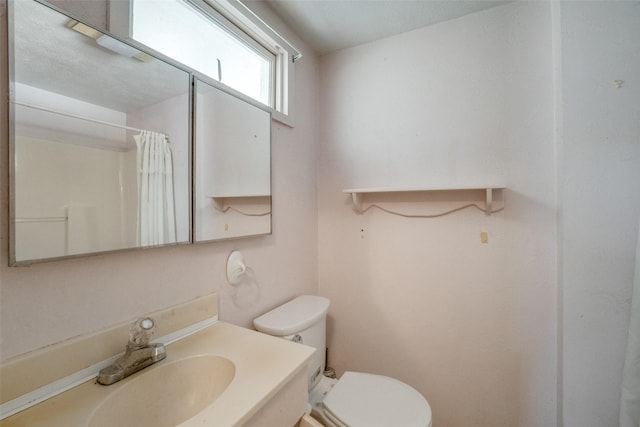 bathroom featuring a shower with curtain, vanity, and toilet