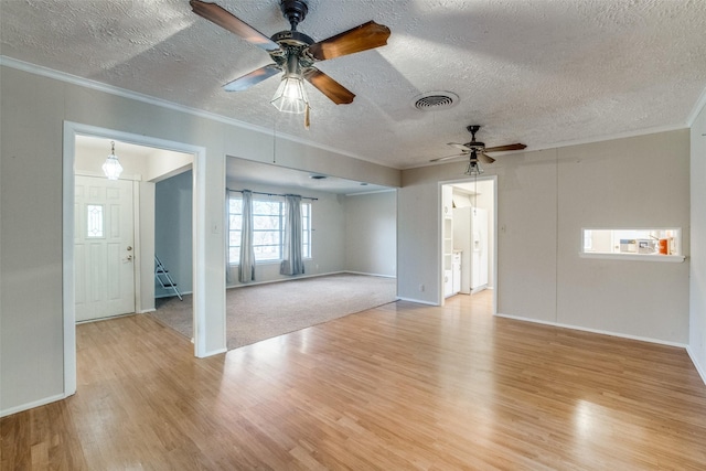 unfurnished living room featuring ceiling fan, ornamental molding, light hardwood / wood-style floors, and a textured ceiling