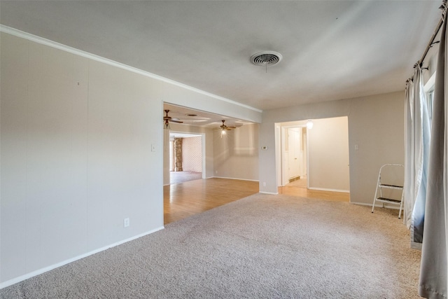 unfurnished room with crown molding, light colored carpet, and ceiling fan