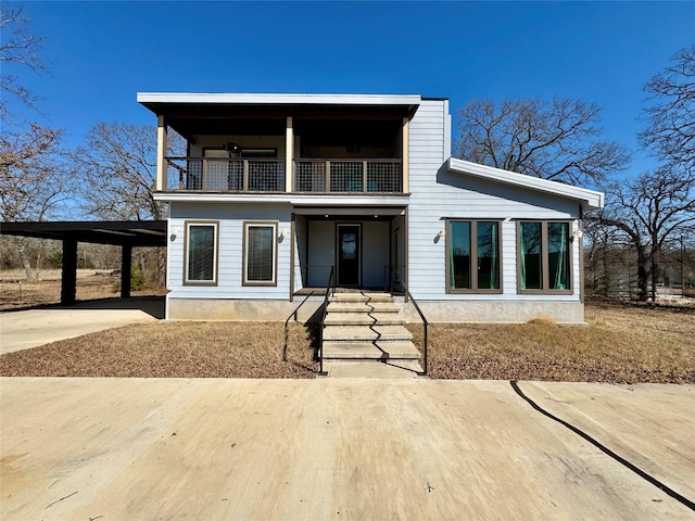 view of front facade with a balcony and a carport