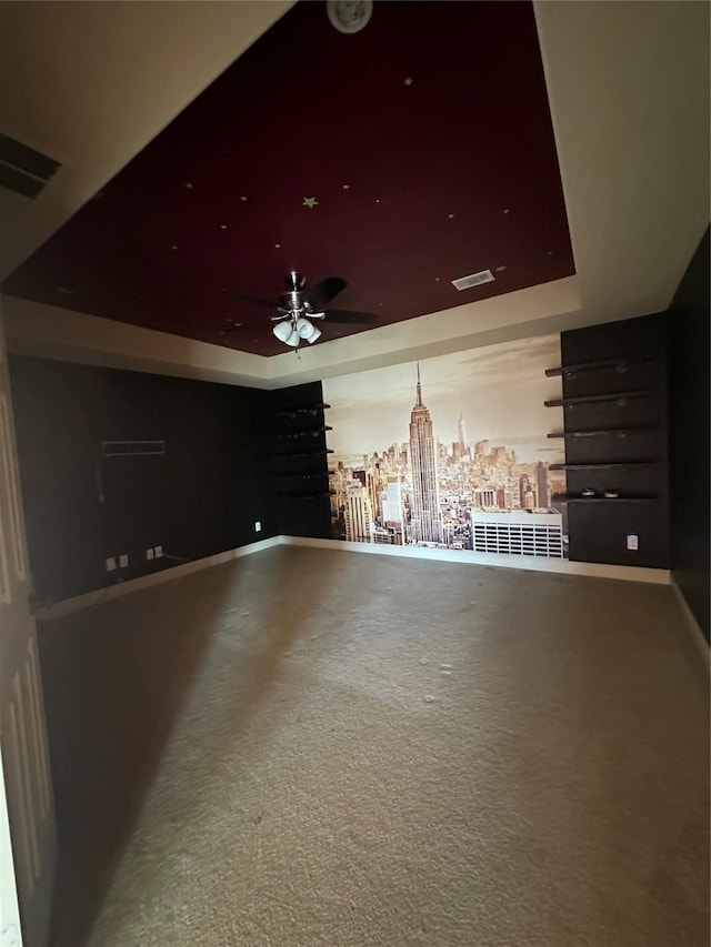 interior space featuring ceiling fan and a tray ceiling