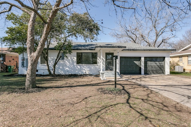 ranch-style home with a garage and cooling unit