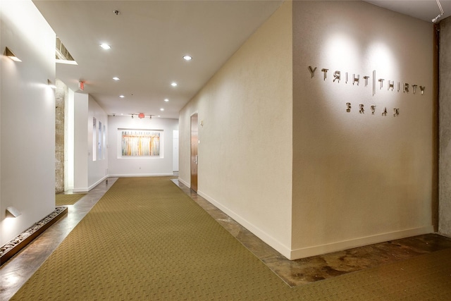 corridor featuring baseboards and recessed lighting