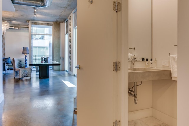 bathroom featuring sink, a wall of windows, and concrete floors