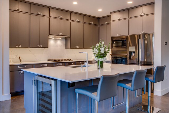 kitchen featuring light stone counters, sink, backsplash, and appliances with stainless steel finishes