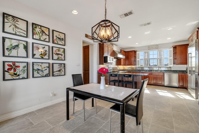 dining space featuring sink and a chandelier