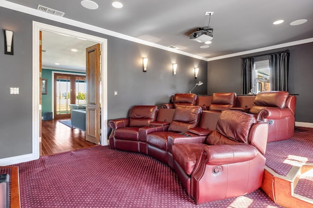 cinema room with ornamental molding and hardwood / wood-style floors