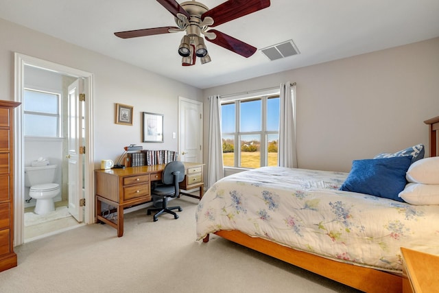 carpeted bedroom with ceiling fan and ensuite bath