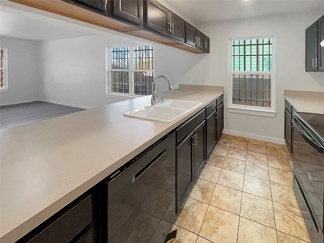 kitchen featuring dark brown cabinetry, sink, light tile patterned floors, dishwasher, and range with electric cooktop