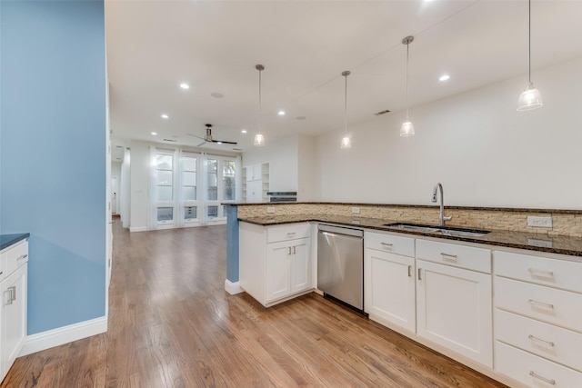 kitchen featuring sink, white cabinetry, dishwasher, pendant lighting, and dark stone counters