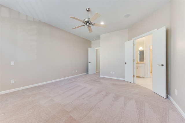 unfurnished bedroom featuring light carpet, connected bathroom, lofted ceiling, and ceiling fan