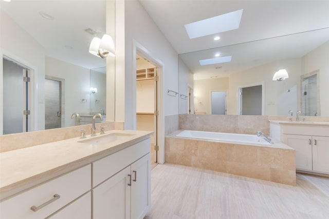 bathroom featuring vanity, a skylight, and separate shower and tub