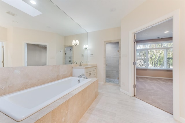 bathroom featuring vanity, tile patterned flooring, a skylight, and separate shower and tub