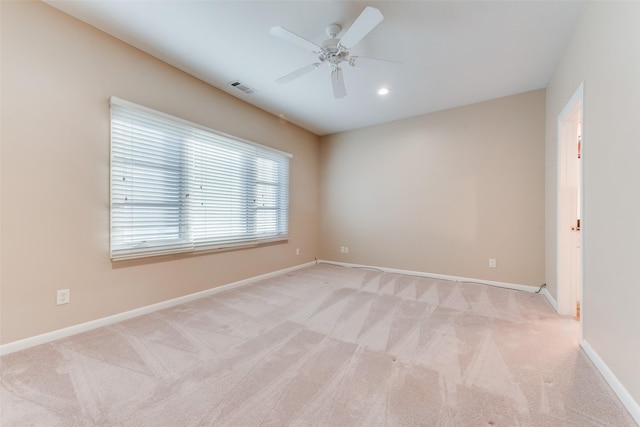 empty room featuring ceiling fan and light colored carpet