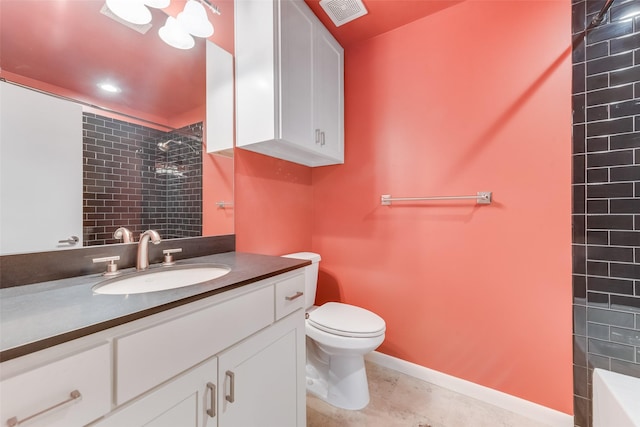 bathroom with tiled shower, vanity, and toilet