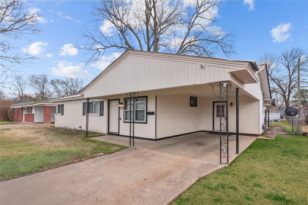 ranch-style house featuring a carport and a front yard