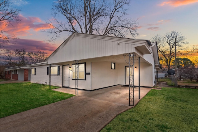 view of front of property with a carport and a yard