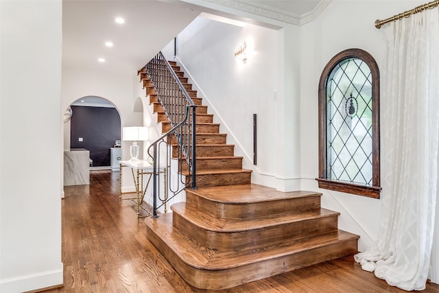 entryway with ornamental molding and dark hardwood / wood-style floors