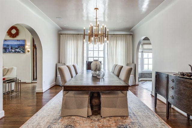 dining space featuring a notable chandelier, dark wood-type flooring, and ornamental molding