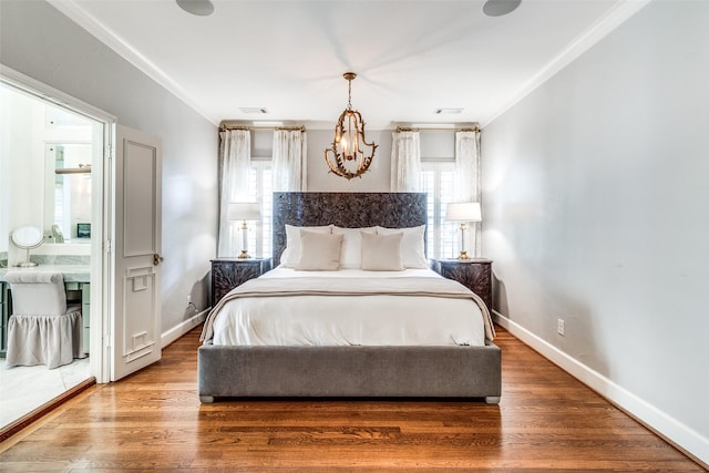 bedroom with hardwood / wood-style floors, crown molding, and a notable chandelier