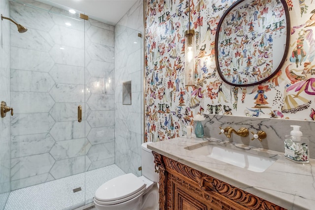 bathroom with vanity, a shower with door, and toilet